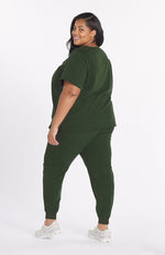 Woman wearing dark olive the Mayfair 2 pocket scrub top from DOLAN