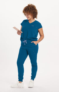 Woman in caribbean blue Cypress two pocket scrub top from DOLAN