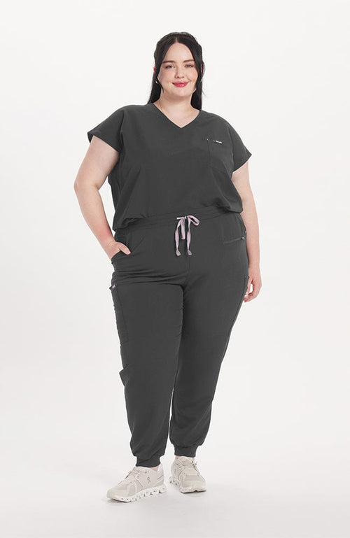 Woman in v neck scrub top with drop shoulder and 2 pockets in charcoal