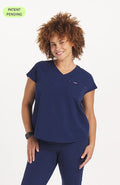 Woman in v neck scrub top with drop shoulder and 2 pockets in navy blue