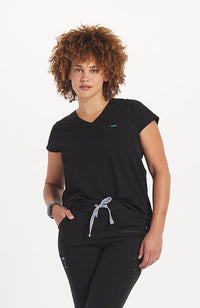 Woman in v neck scrub top with drop shoulder and 2 pockets in black