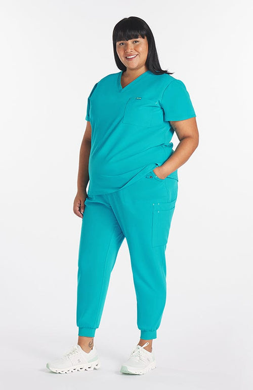 Super comfortable teal colored scrub pants with 11 pockets and V neck top on woman