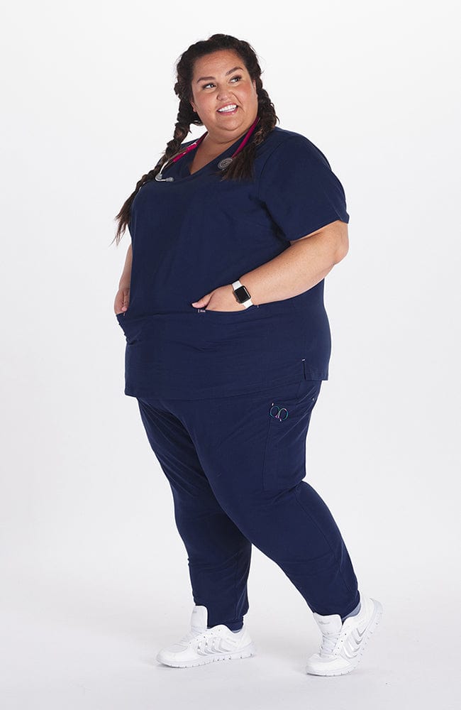 Woman in high waisted Hope 11 Pocket Jogger scrub pant in Navy