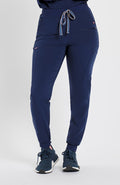 Woman in high waisted Hope 11 Pocket Jogger scrub pant in Navy