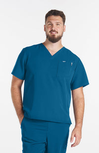 Man wearing Caribbean Blue Miguel V Neck 3-Pocket Men's CORE Scrub Top - DOLAN