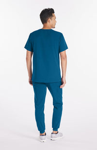 Man wearing Ravi Crew Neck 3-Pocket Men's CORE Scrub Top in Caribbean Blue