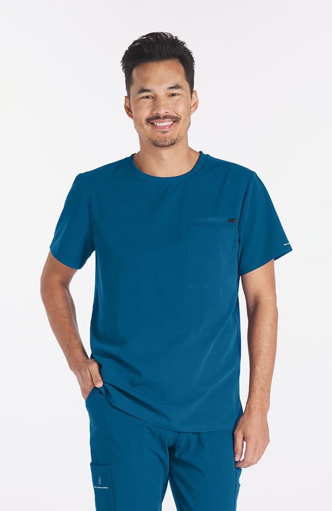 Man wearing Ravi Crew Neck 3-Pocket Men's CORE Scrub Top in Caribbean Blue