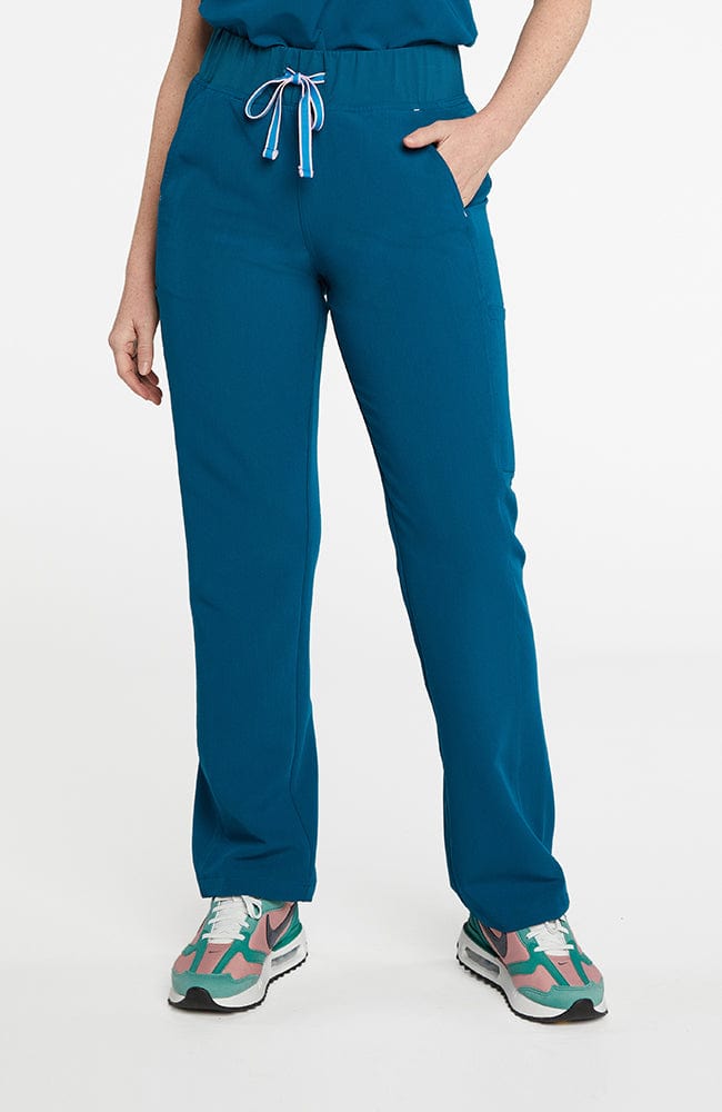 A woman wearing District high-waisted scrub pants 6-pocket CORE scrub in caribbean blue.