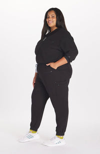 Woman in high waisted Hope 11 Pocket Jogger scrub pant in Black
