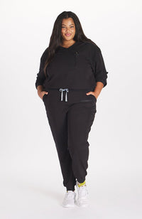 Woman in high waisted Hope 11 Pocket Jogger scrub pant in Black