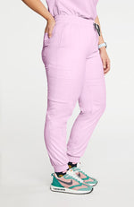 A woman wearing Huntington high-waisted jogger pants 7-pocket TLC scrub in lilac.