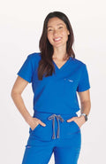 Woman in royal blue V neck scrub top by DOLAN