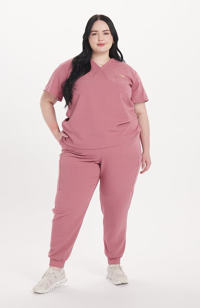 Woman in rosewood pink scrub color V neck scrub top
