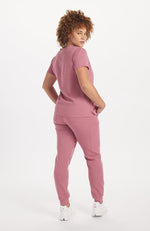 Woman in rosewood pink scrub color V neck scrub top